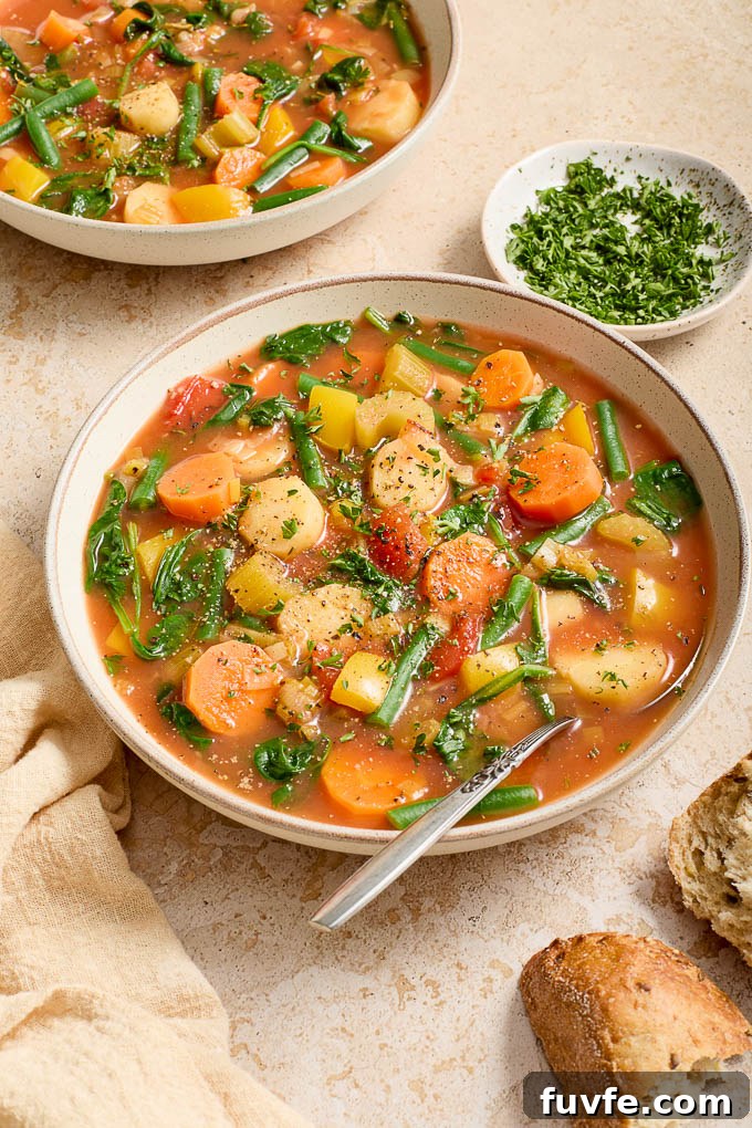 Bowl of Instant Pot vegetable soup with a spoon and garnished with parsley