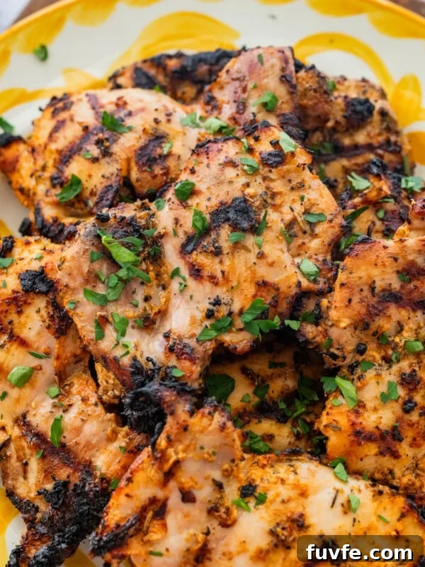 Chicken on a serving dish with garnish.