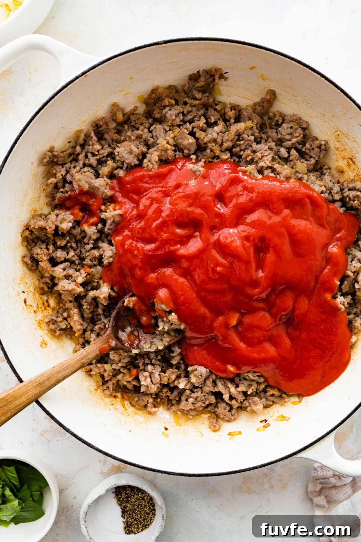 How to make classic pasta al forno step-by-step: adding the tomato passata to the pan.