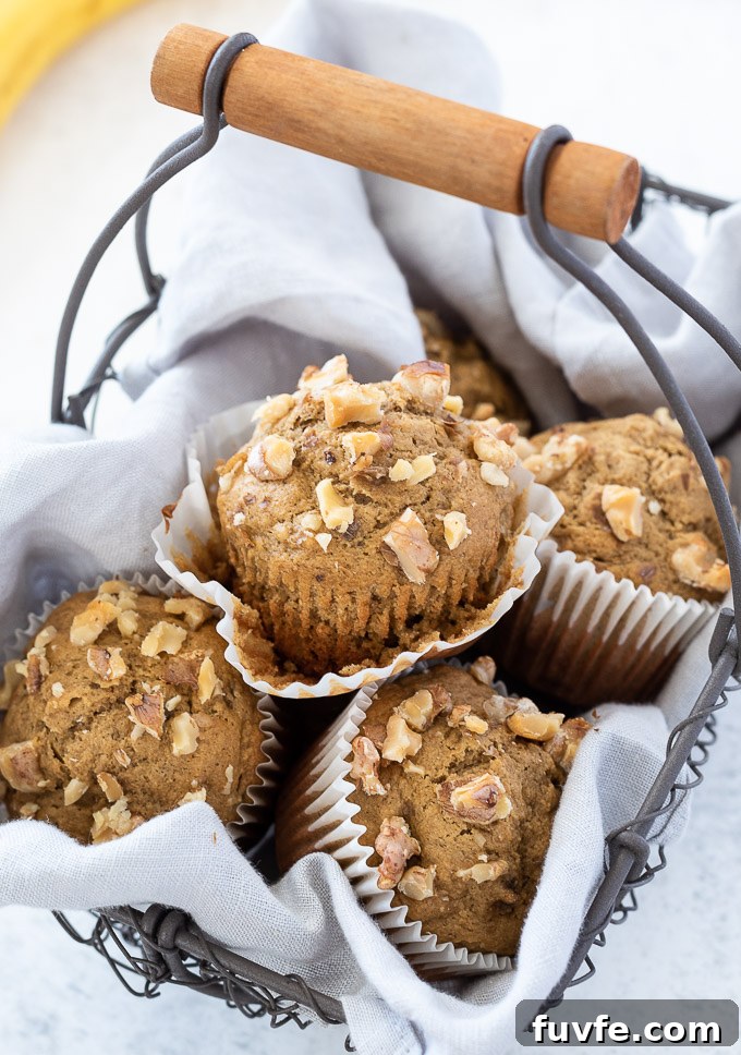 Moist Banana Oat Flour Muffins Recipe 3 Banana oatmeal muffins in a basket with paper liner removed on top muffin