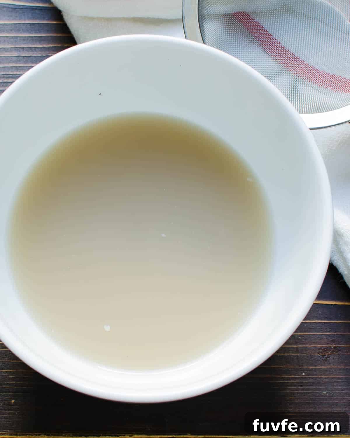 Traditional Oyster Stew Recipe: Creamy New England Style 4 Reserved oyster liquid in a bowl.