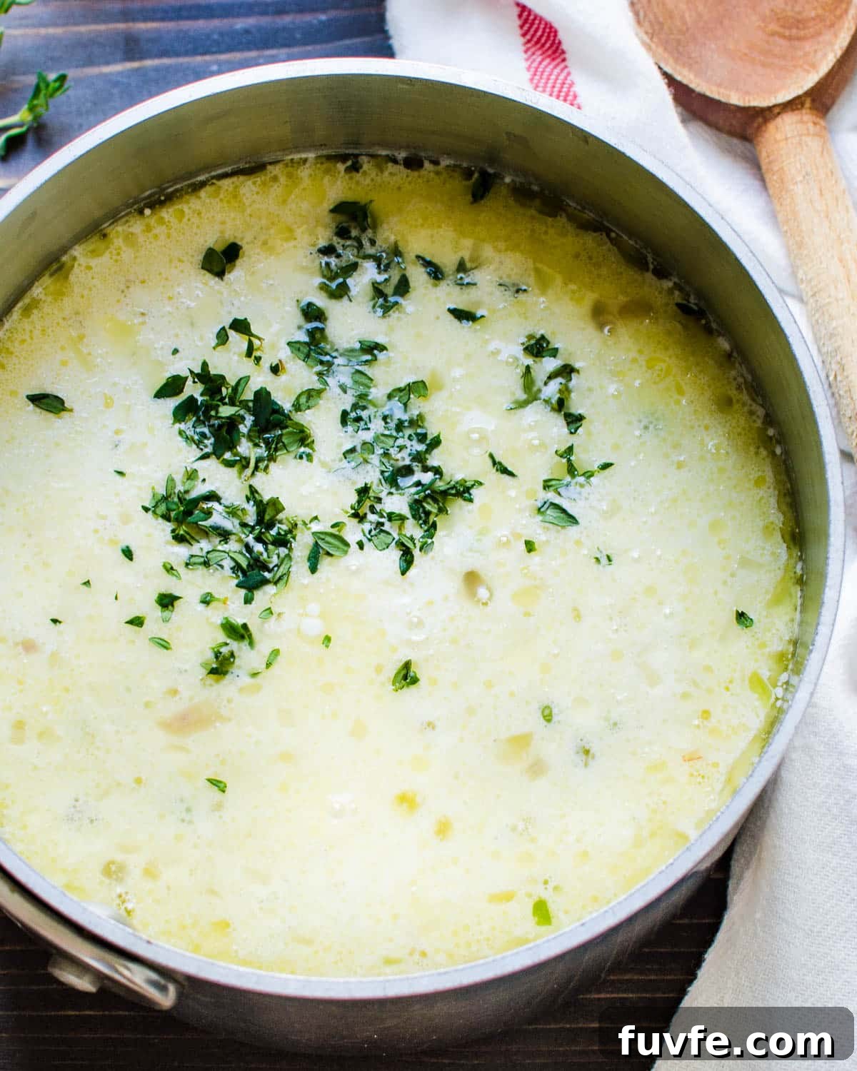 Traditional Oyster Stew Recipe: Creamy New England Style 7 Adding milk and parsley in a pot to heat.
