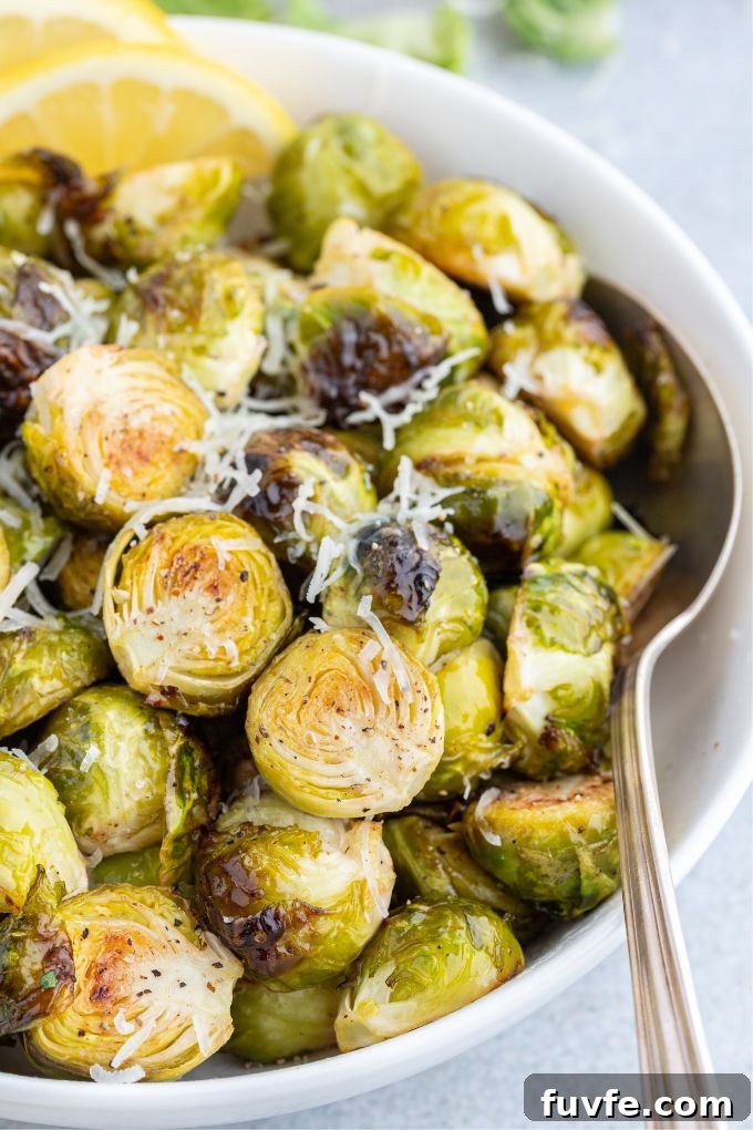 How to Make Crispy Air Fryer Brussels Sprouts 7 Air fried brussels sprouts in a white bowl with serving spoon