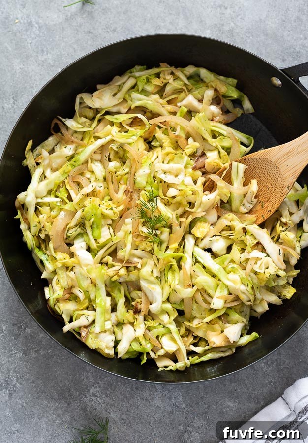 sautéed cabbage in skillet with wooden spoon