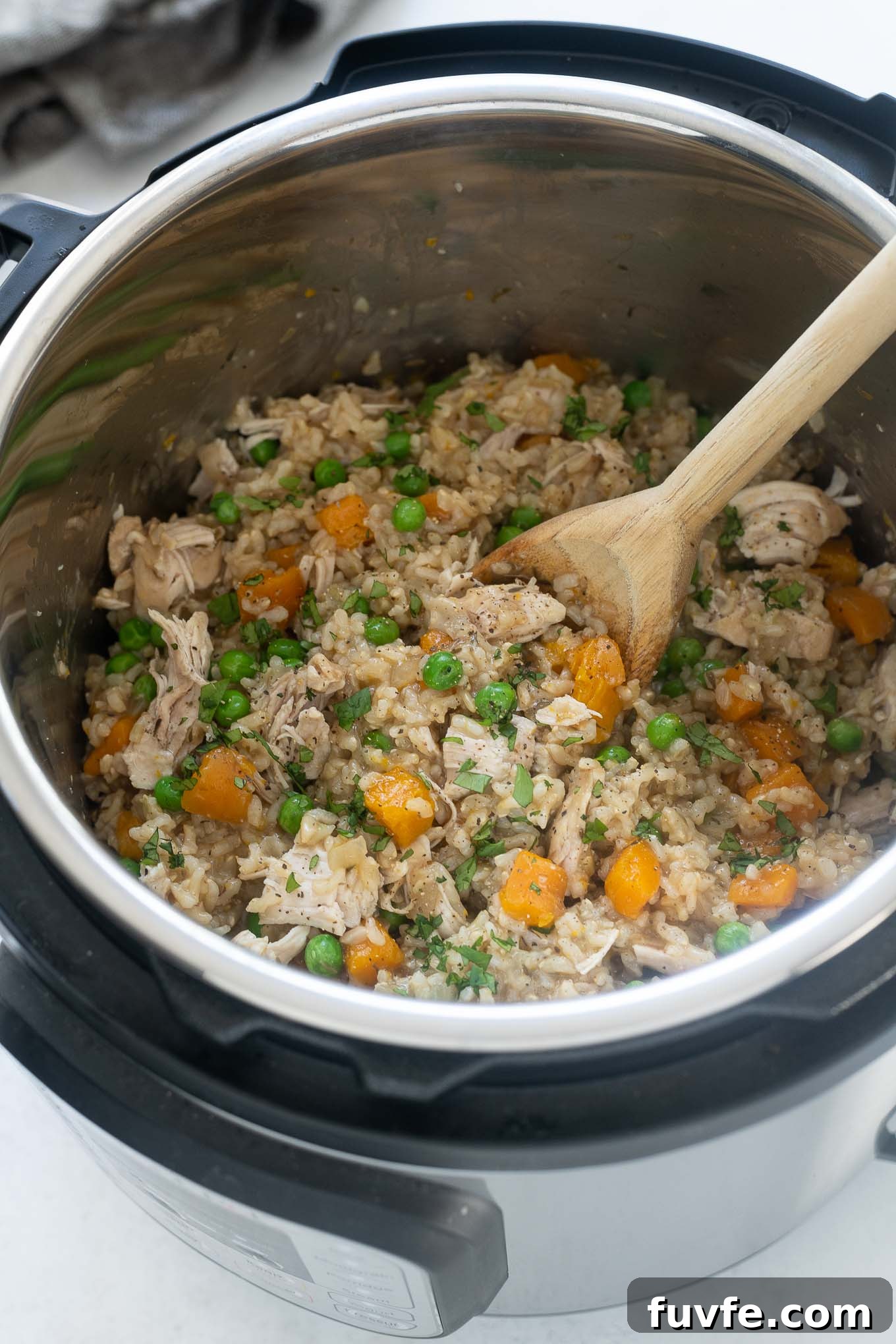 Chicken and rice in the instant pot with wooden spoon digging in