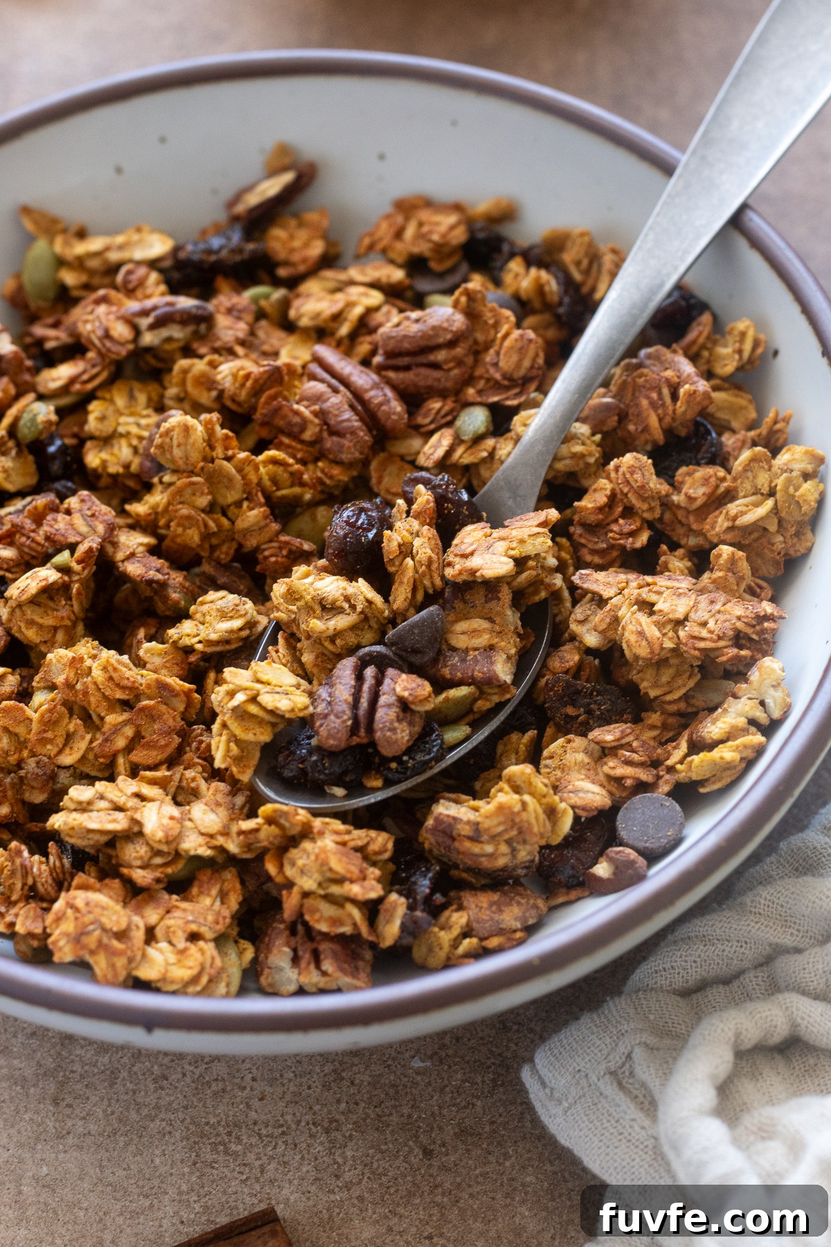 Spoonful of pumpkin spice protein granola in a bowl.