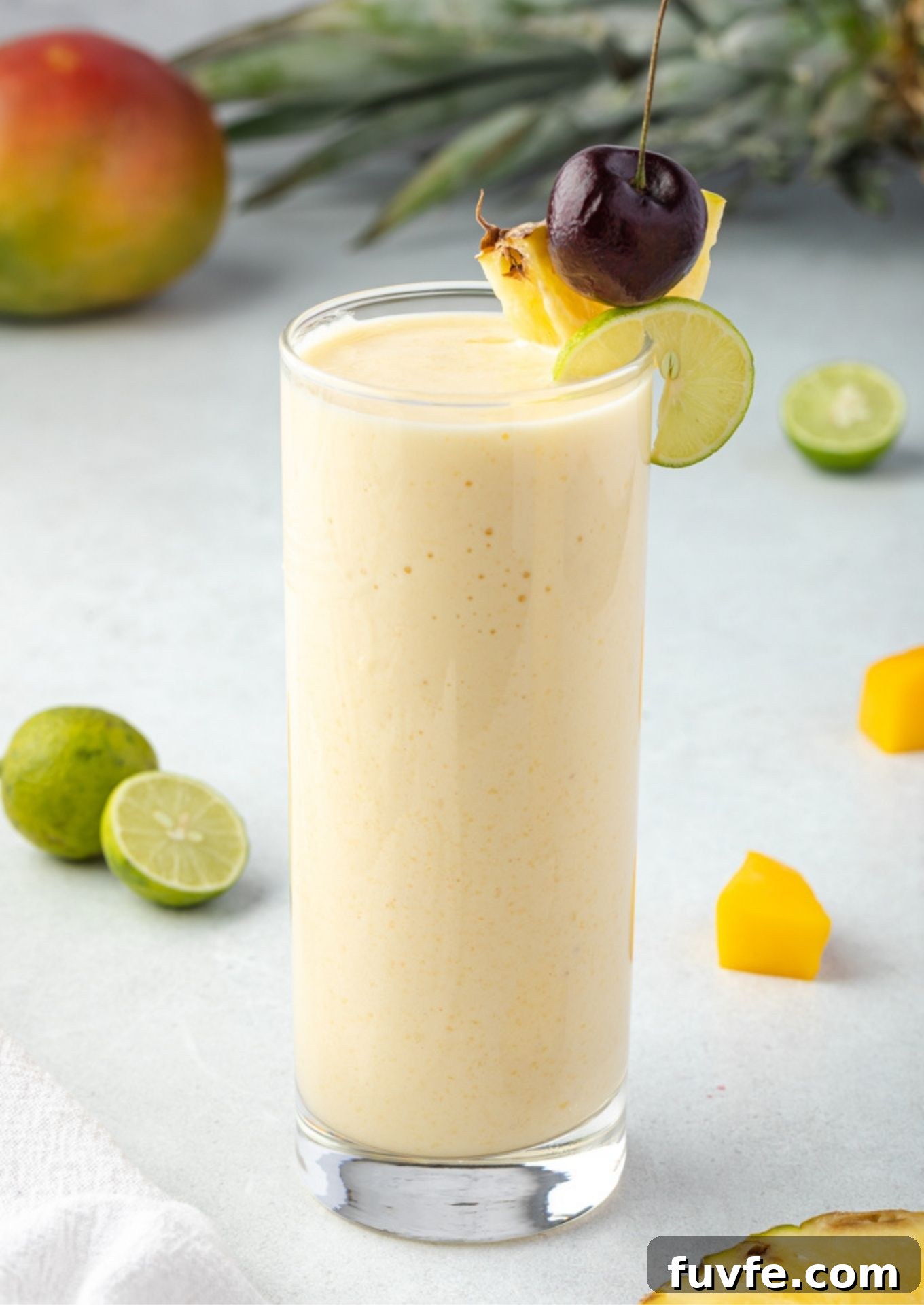 Tropical smoothie with pineapple cherry and lime on rim