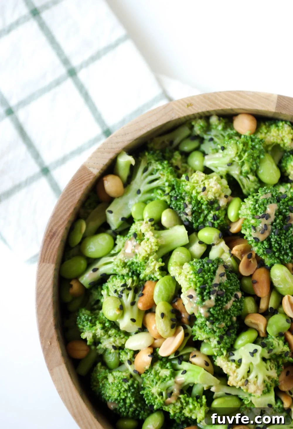 close up of a wooden bowl filled with Asian Broccoli Salad