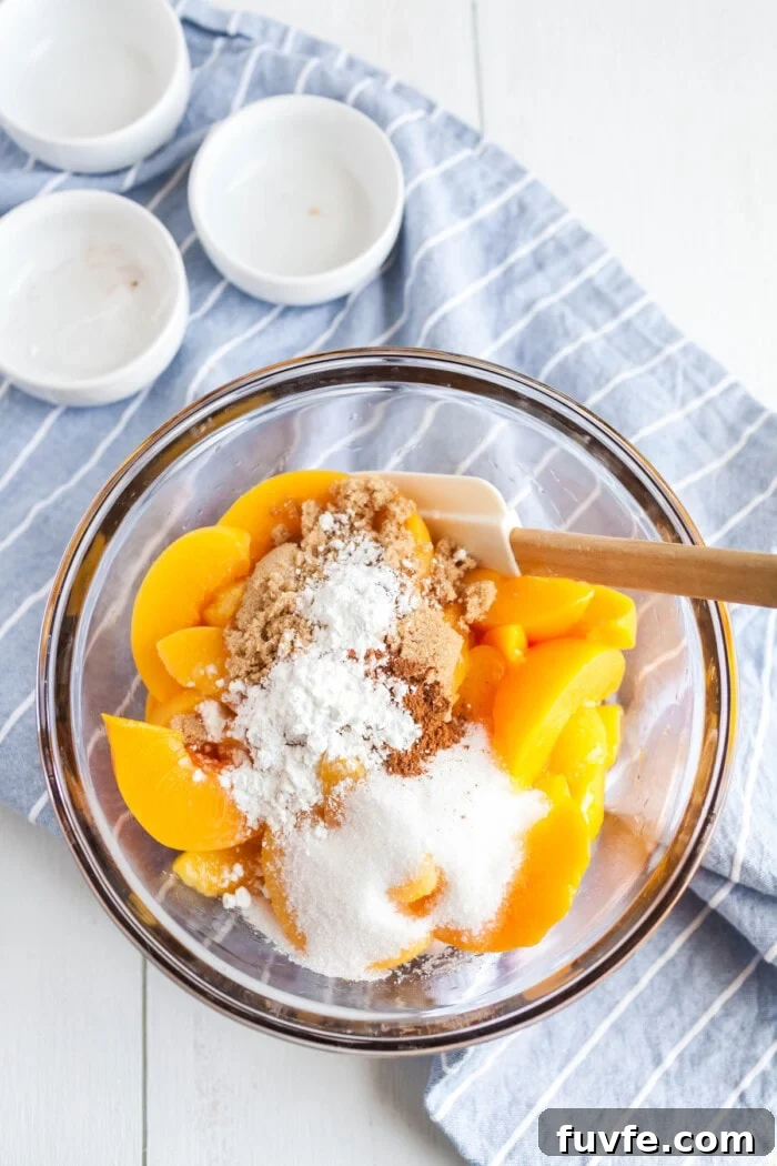 peaches in bowl with dry ingredients for cobbler
