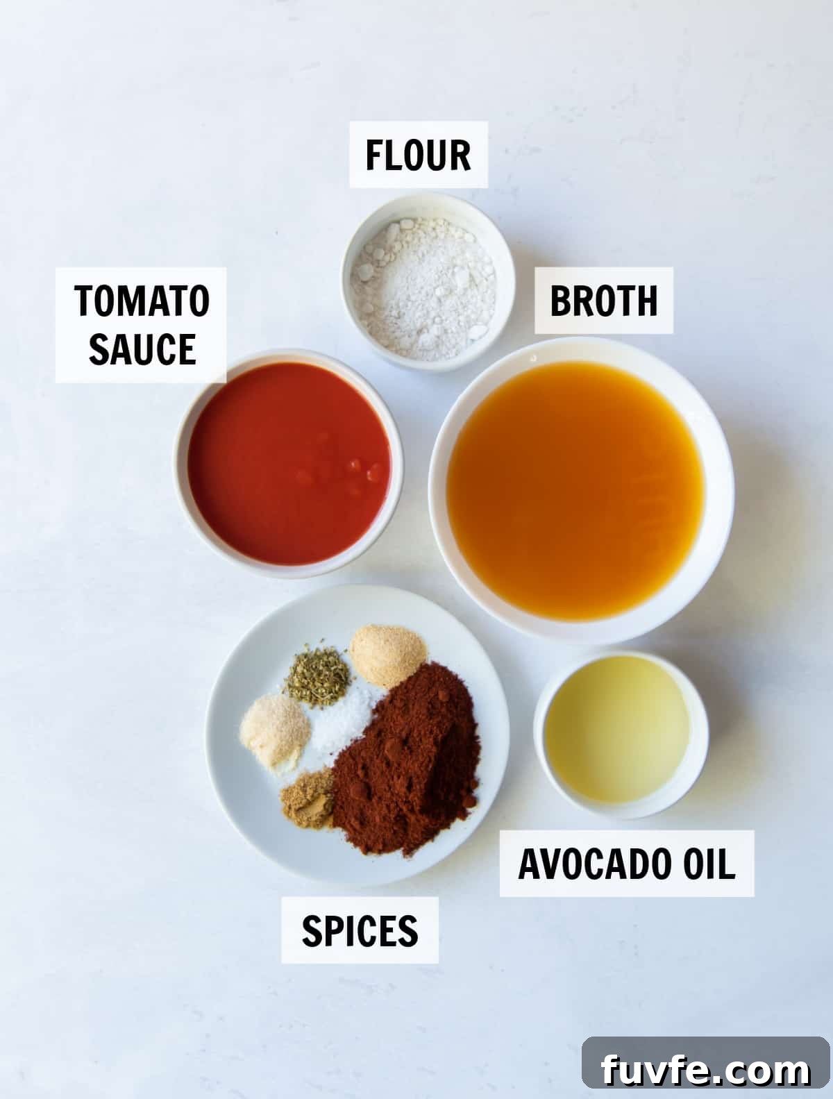 All the ingredients and spices for easy enchilada sauce measured in white bowls