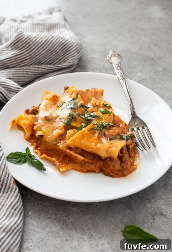 serving of skillet lasagna on plate with basil on top and alongside