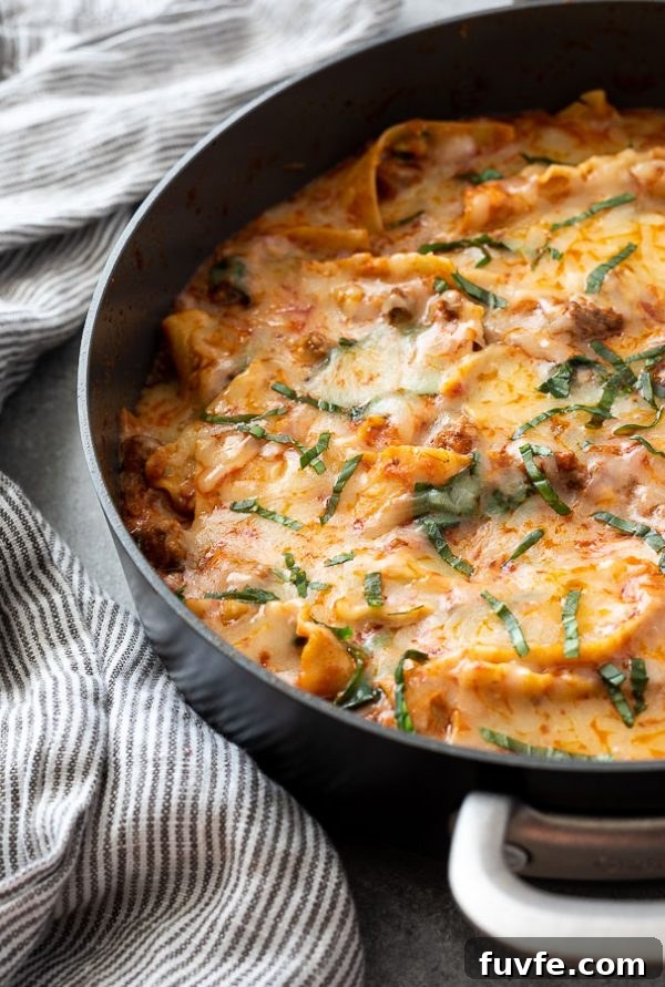 One-Pan Skillet Lasagna Recipe with Melty Mozzarella 4 close up of stove top lasagna with chopped basil on top and linen alongside