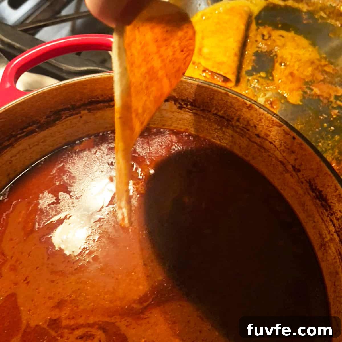 Dipping a tortilla shell in sauce.