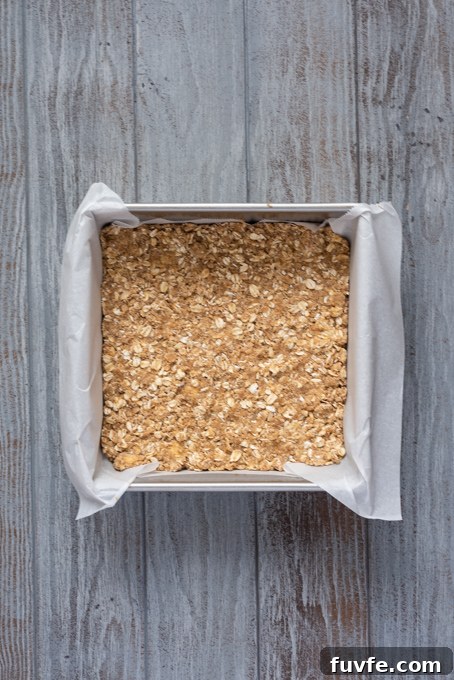 Blueberry Crumble Bars Recipe with Oat Crust 5 Par baked oat crumble crust in pan.