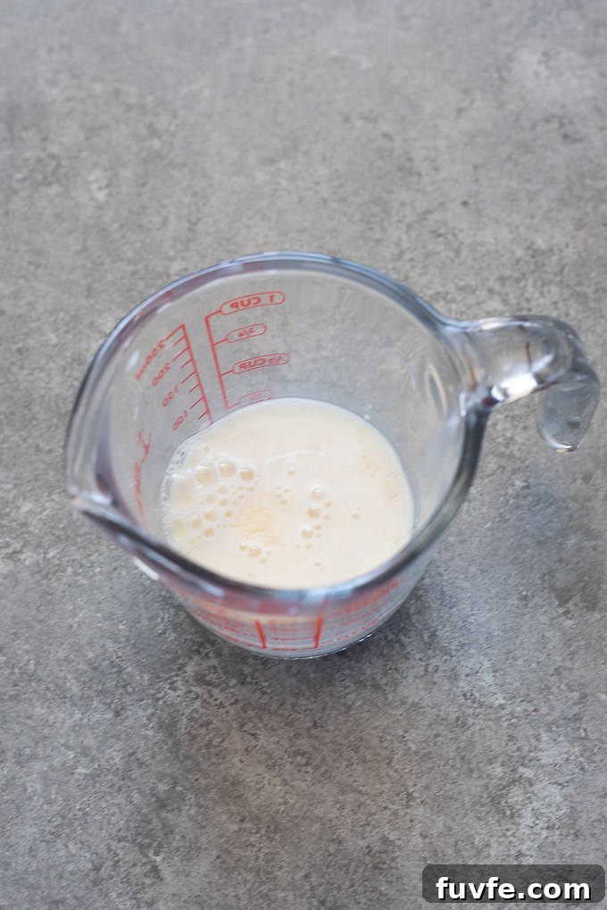 Milk and vinegar combined in a measuring cup for galette dough.