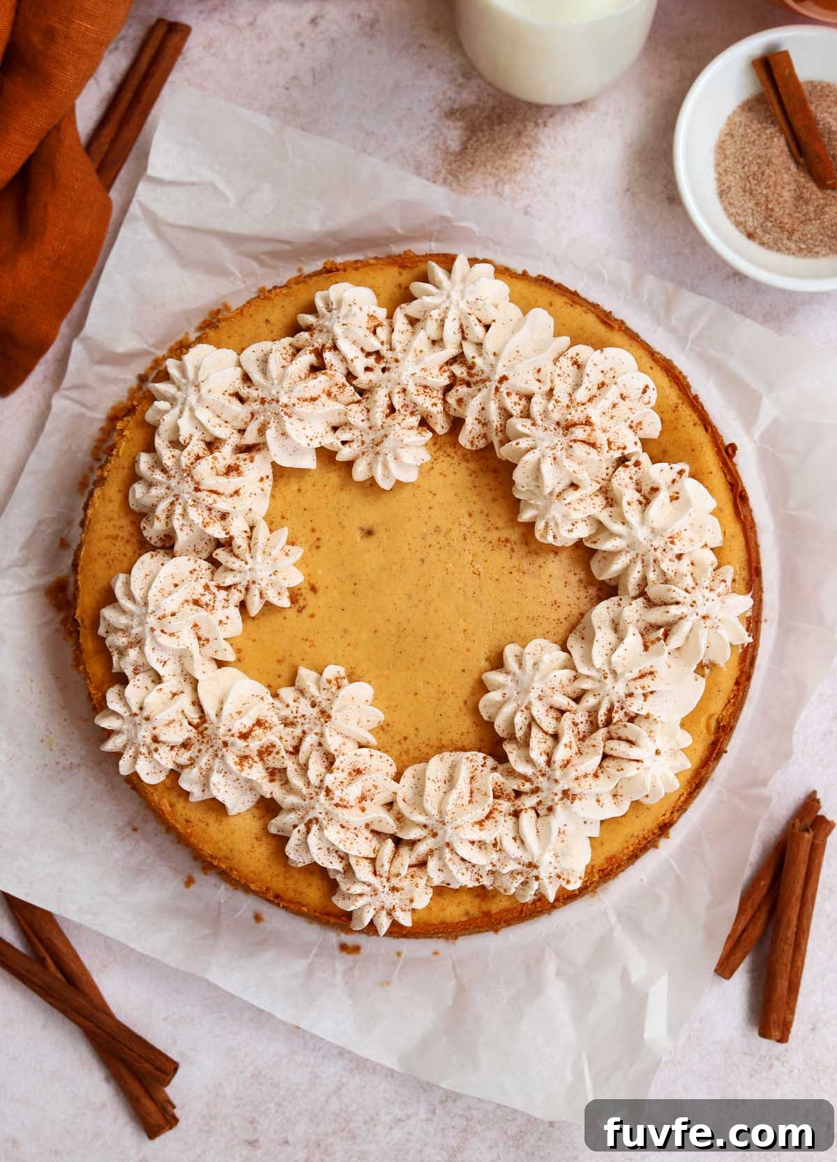 top view of cinnamon swirl pumpkin cheesecake with whipped cream topping