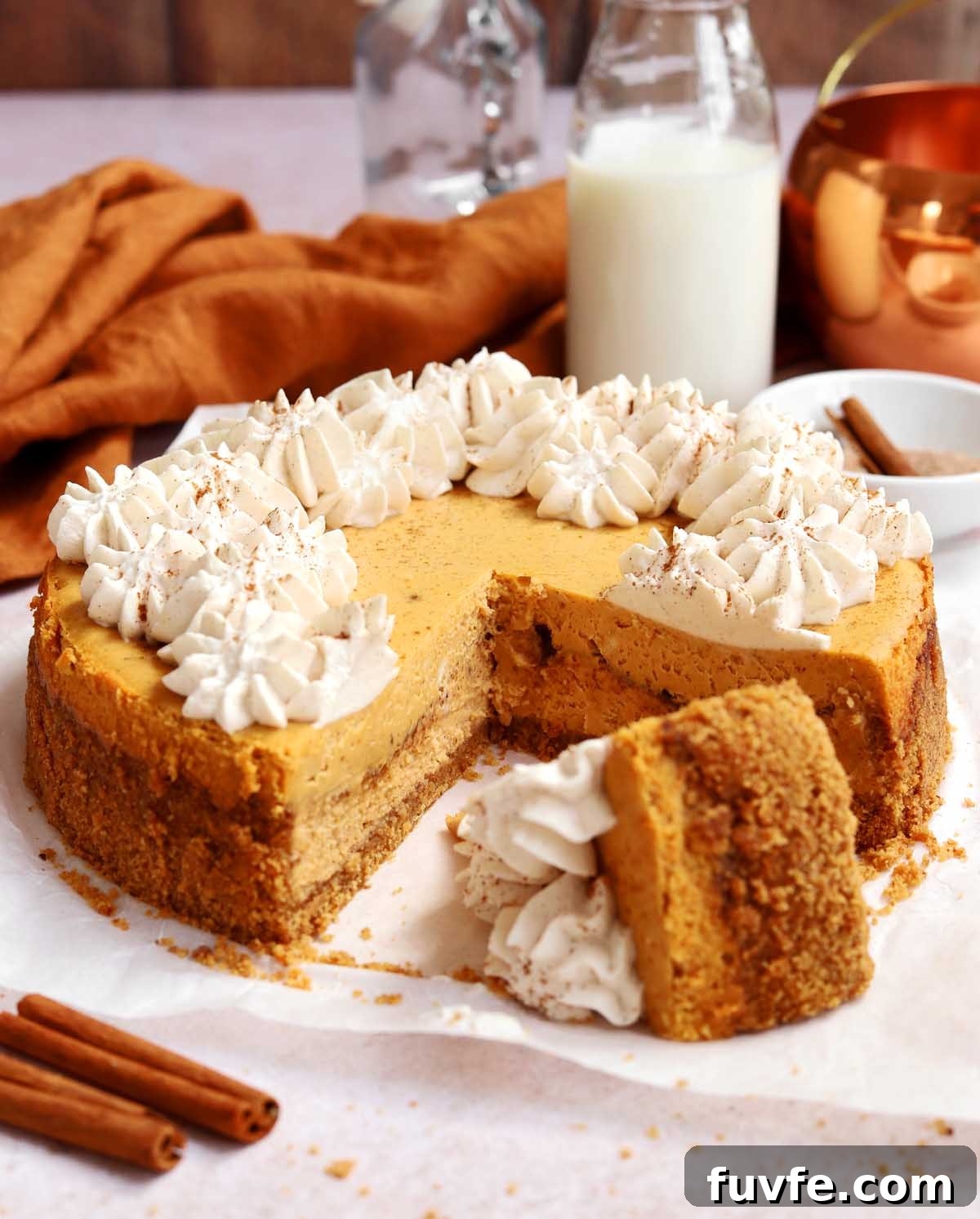 cinnamon swirl pumpkin cheesecake with slice cut out