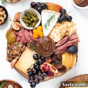 Cheese board filled with a variety of meats, cheeses, fruit and crackers