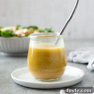 Apple cider vinegar dressing in jar with salad in background