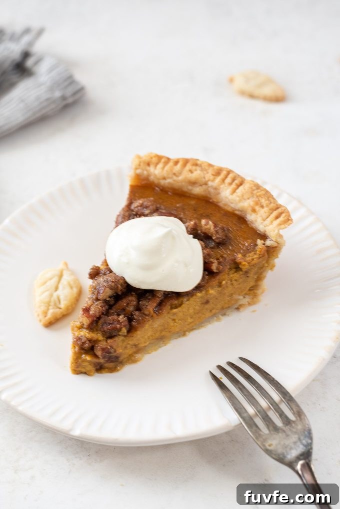 Slice of pumpkin pie on a plate with whipped cream on top