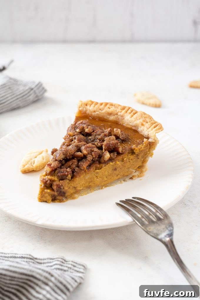 Slice of pumpkin pecan pie on a white plate