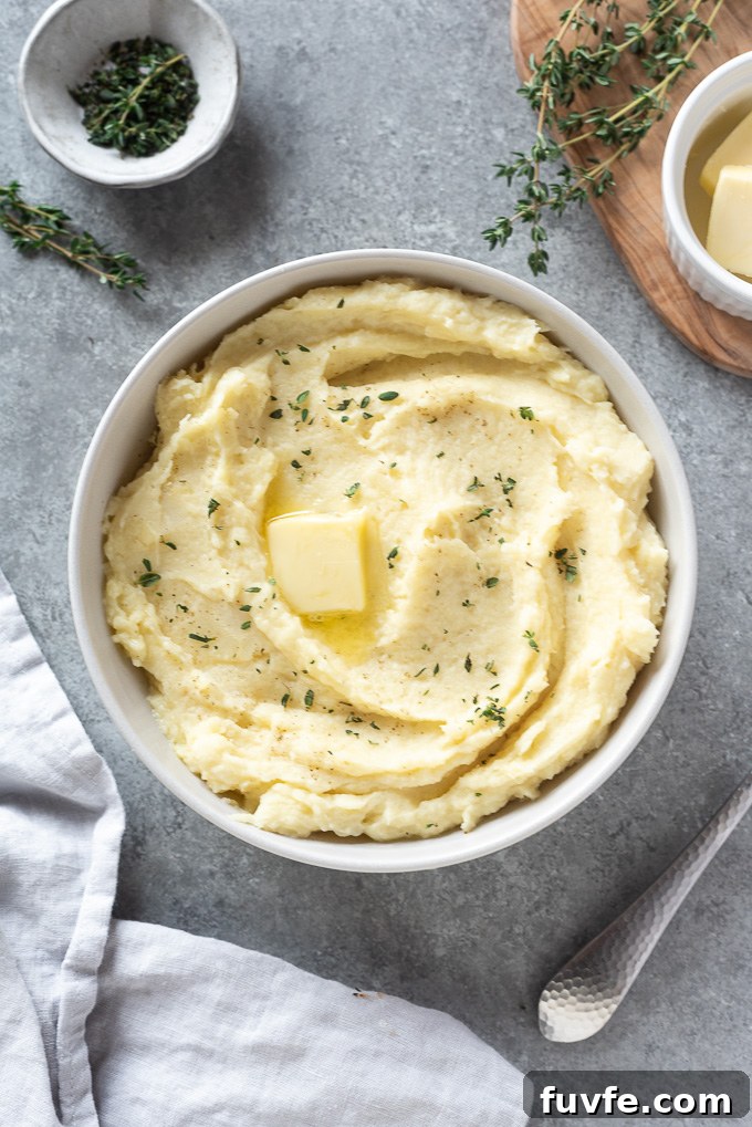 How to Make Creamy Parsnip Puree 3 Parsnip mash in a bowl with a pat of butter and thyme leaves