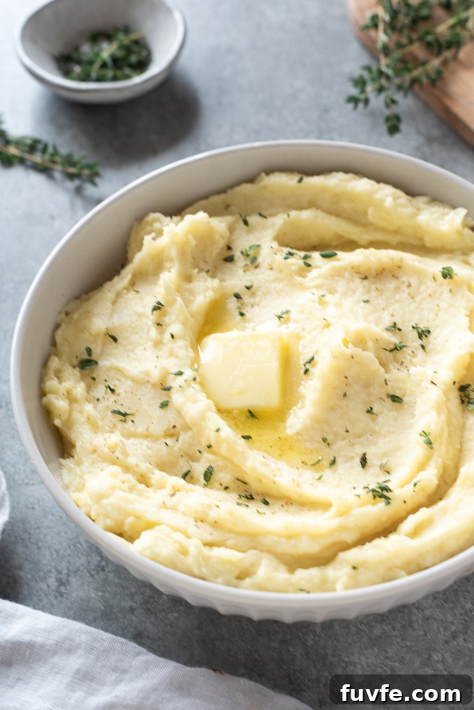 How to Make Creamy Parsnip Puree 6 Parsnip puree in a white bowl with butter and thyme leaves on top