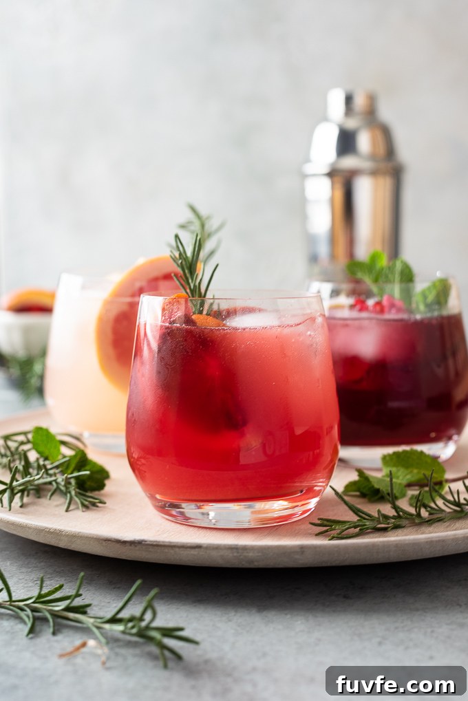 Vodka spritzers on server with herbs and cocktail shaker in background