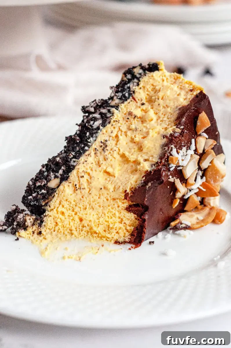 a slice of no-bake nanaimo bar cheesecake laying on its side on a white late. It looks like a fork has taken a bite out of the end.