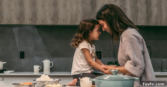 A child sitting on a counter holding hands with a women.