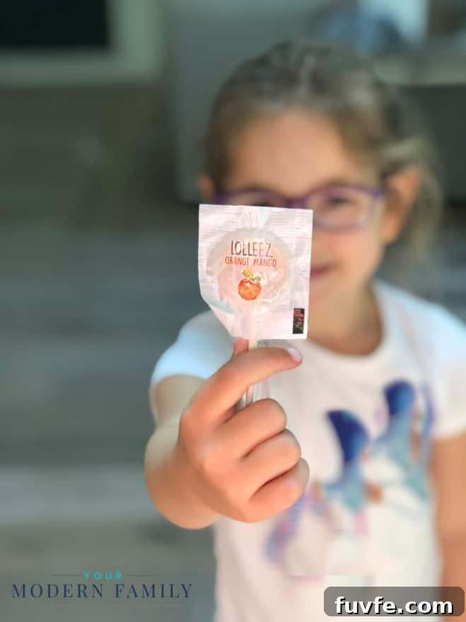 A little girl holding a lollipop.