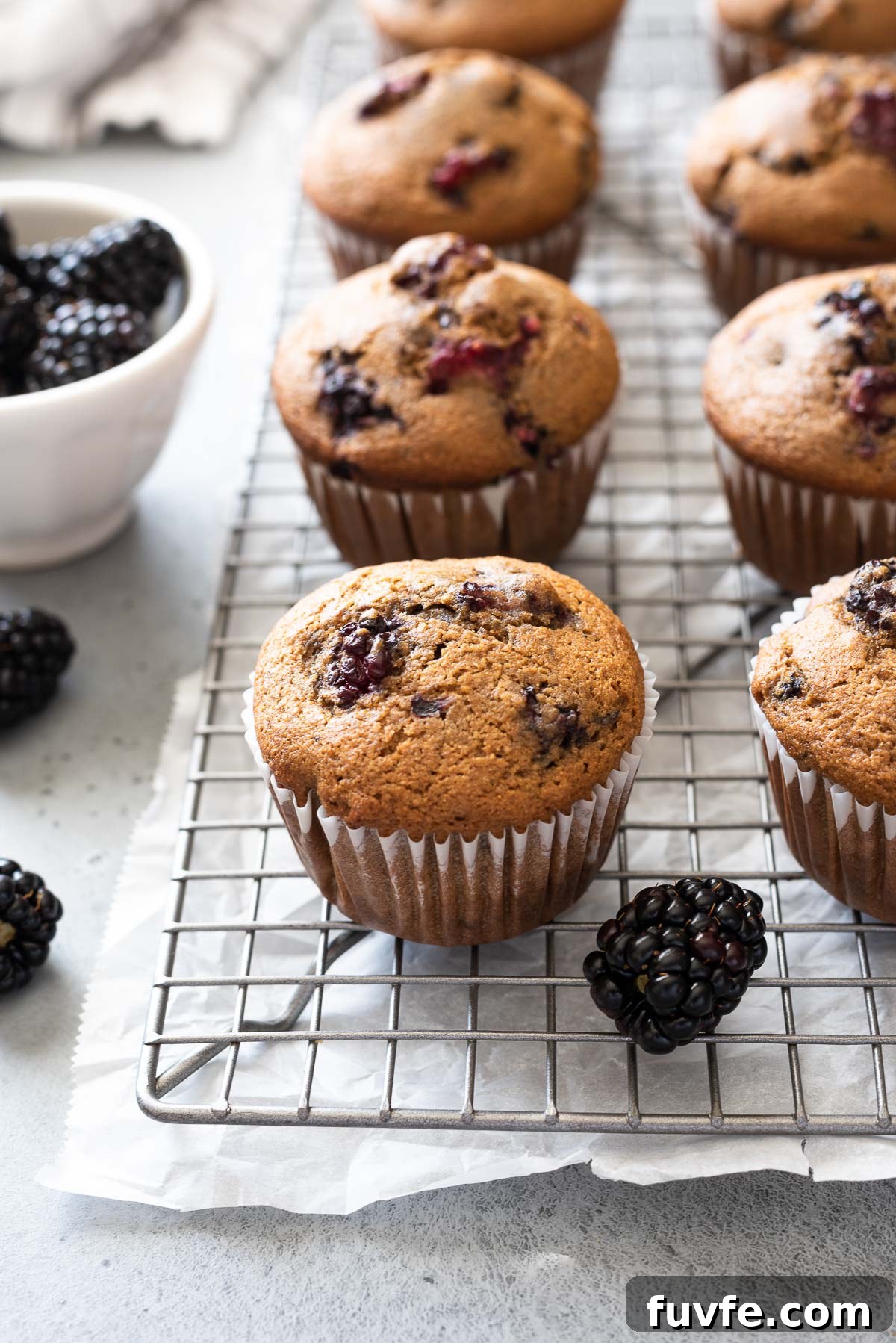 Homemade Blackberry Cinnamon Muffins Recipe 2 Blackberry muffins on wire rack with fresh blackberries