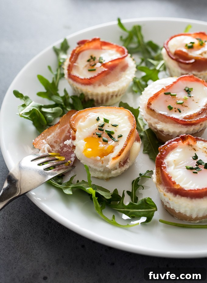 Bacon and Egg Breakfast Muffins Recipe 6 Bacon egg muffins with fork breaking yolk