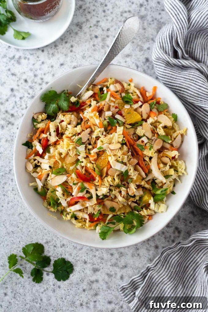 Napa cabbage salad in a white bowl with spoon