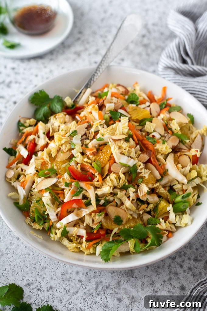 Asian napa cabbage salad in a white bowl with cilantro on top