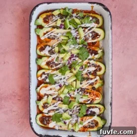 enchilada stuffed zucchini boats topped with sour cream, avocado, and cilantro