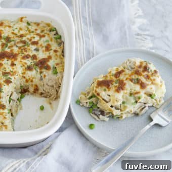 a serving of tuna noodle casserole on a plate next to a casserole dish of tuna noodle casserole