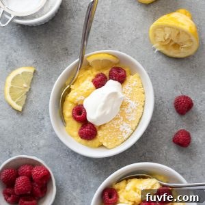 Lemon pudding cake in bowls with raspberries and whipped cream