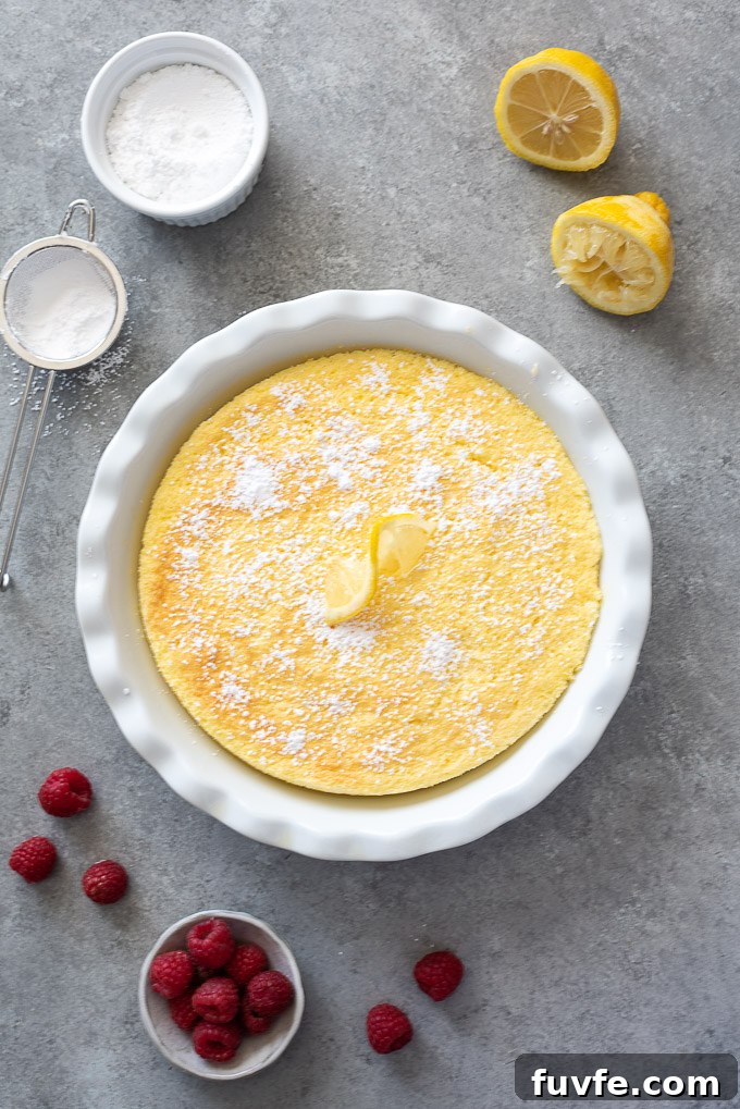 Lemon Pudding Cake Recipe with Silky Custard 3 Lemon pudding cake in baking dish with powdered sugar on top