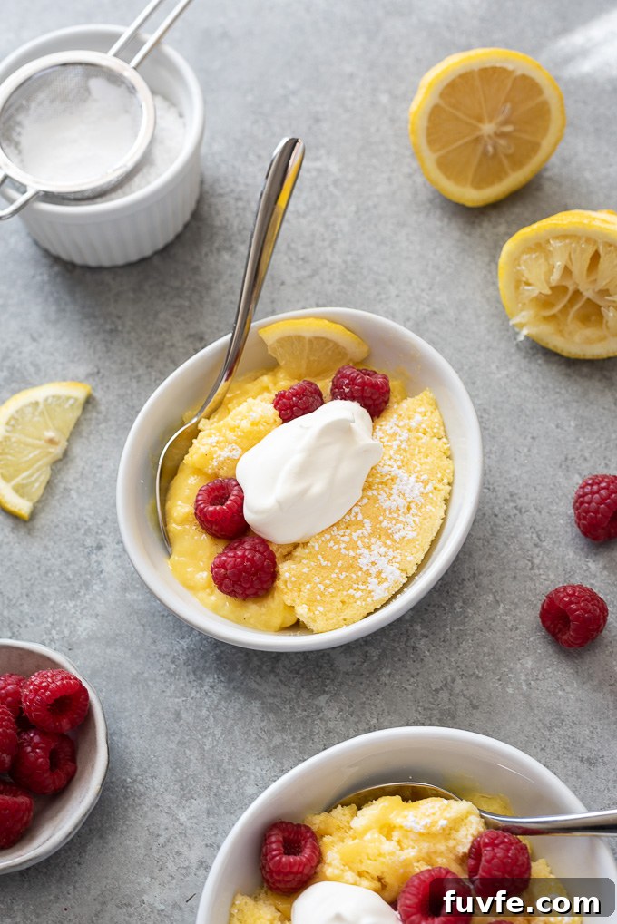 Serving of lemon pudding cake in a bowl with whipped cream and berries
