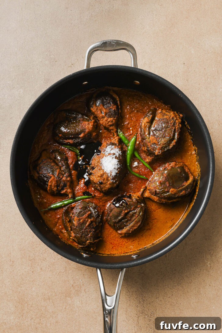 Green chili, tamarind and sugar added to skillet with Bagare Baingan.