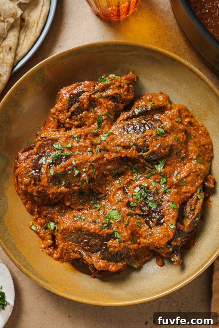 Close up of Bagare Baingan in a plate garnished with minced cilantro.