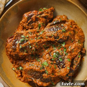 Close up of Bagare Baingan in a plate garnished with minced cilantro.