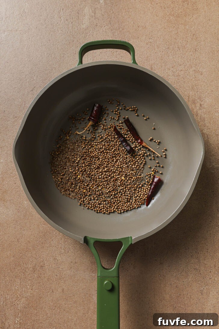 Toasting whole spices in a skillet to make Bagare Baingan.