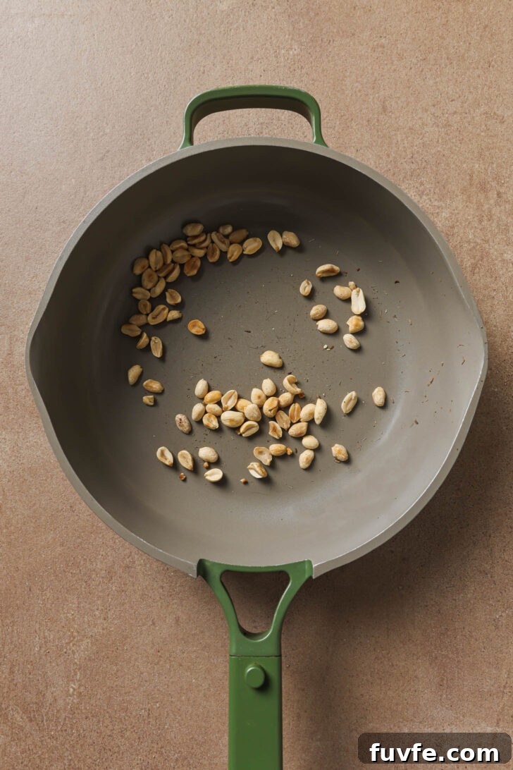 Toasting peanuts in a skillet to make Bagare Baingan.