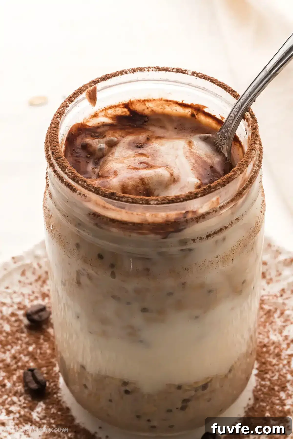 Tiramisu Overnight Oats Recipe — Creamy Coffee Breakfast Jar 2 A jar with tiramisu overnight oats with a spoon in it.