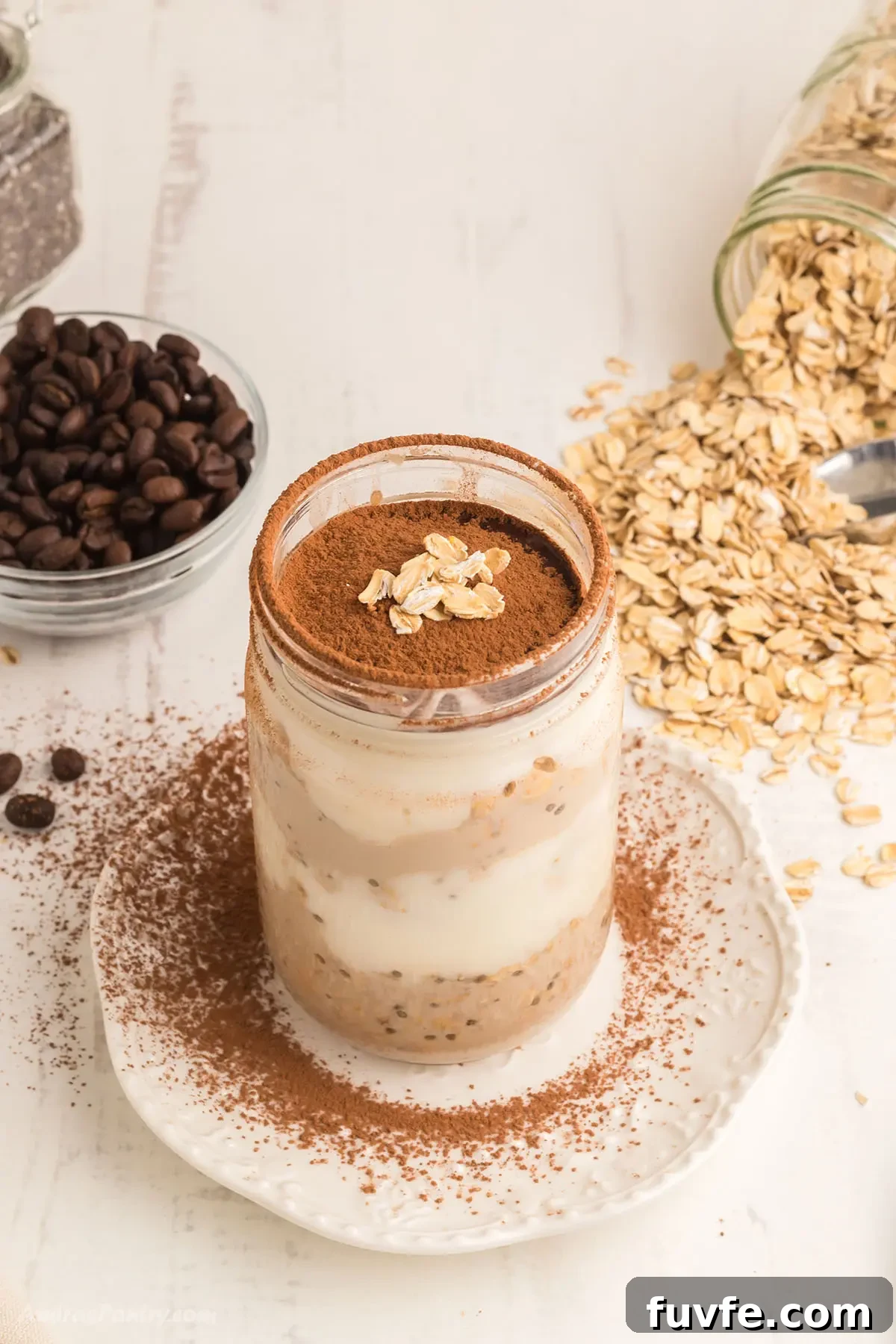 Tiramisu Overnight Oats Recipe — Creamy Coffee Breakfast Jar 5 A jar with overnight oats on a white surface.