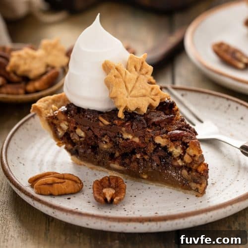 A slice of decadent chocolate pecan pie topped with whipped cream