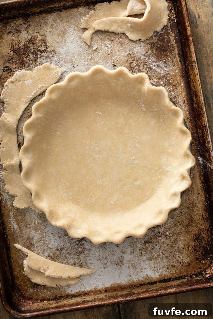 pie crust dough folded perfectly into the pie dish.