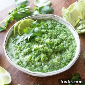Tomatillo salsa recipe in a white bowl with lime and cilantro